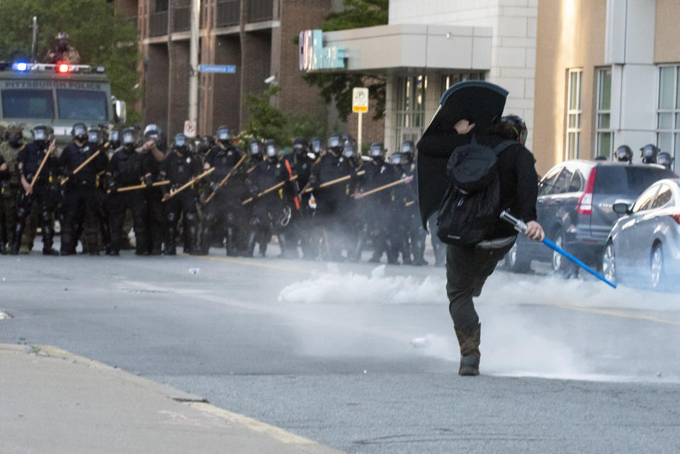 In this Monday, June 1, 2020 photo, a person kicks back a canister of tear gas while taking fire of rubber bullets after police used tear gas and rubber bullets against peaceful protesters before curfew in Pittsburgh, protesting the death of George Floyd, who died after being restrained by Minneapolis police officers on May 25. (Christian Snyder/Pittsburgh Post-Gazette via AP)