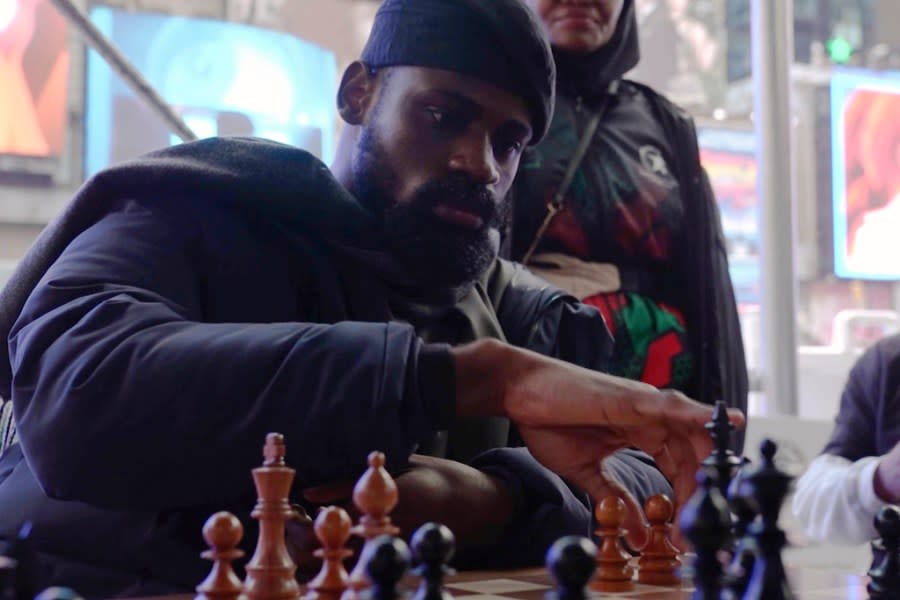 In this screen grab taken from video, Tunde Onakoya, 29- years old, a Nigerian chess champion and child education advocate, play a chess game in Times Square, New York, Thursday, April, 18, 2024. A Nigerian chess player and child education advocate is attempting to play chess nonstop for 58 hours in New York City’s Times Square to break the global record for the longest chess marathon and raise $1m for the education of children across Africa. (AP Video/John Minchillo)