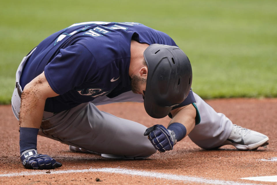 Seattle Mariners' Mitch Haniger lays on the field after getting hit by a pitch in the first inning of a baseball game against the Cleveland Indians, Sunday, June 13, 2021, in Cleveland. Haniger left the game after the incident. (AP Photo/Tony Dejak)