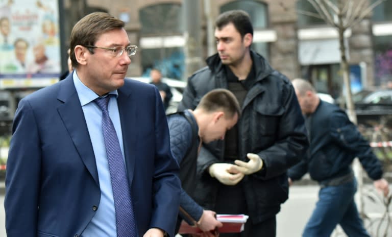 Ukraine's General Prosecutor Yuriy Lutsenko (L) stands on the site where former Russian MP Denis Voronenkov was shot dead on March 23, 2017 in the center of Kiev