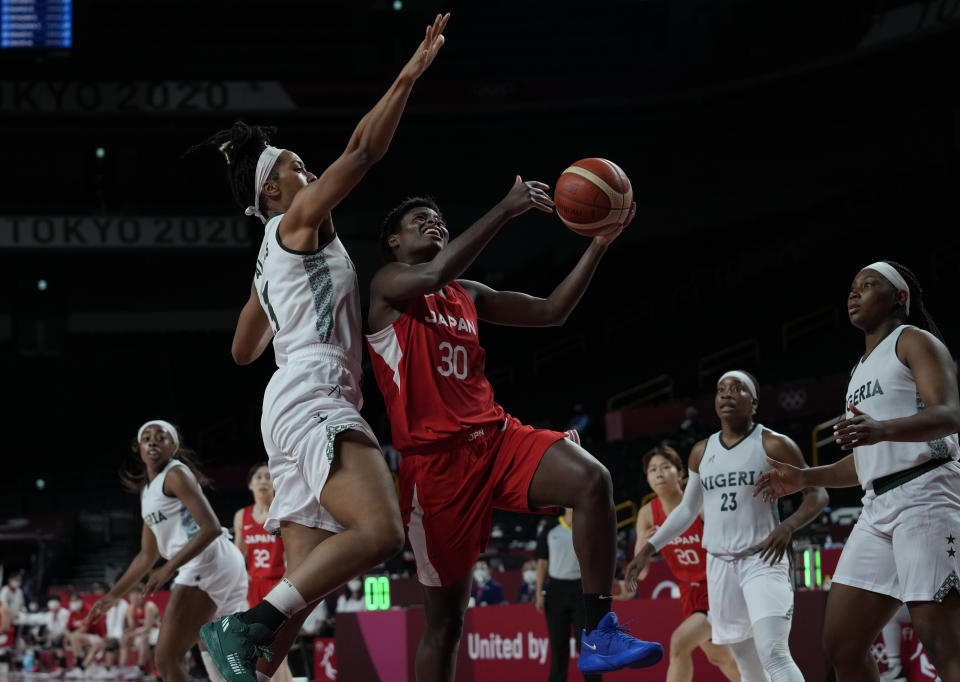 Japan's Evelyn Mawuli (30) drives to the basket past Nigeria's Pallas Kunaiyi-Akpanah (3), center left, during women's basketball preliminary round game at the 2020 Summer Olympics, Monday, Aug. 2, 2021, in Saitama, Japan. (AP Photo/Eric Gay)