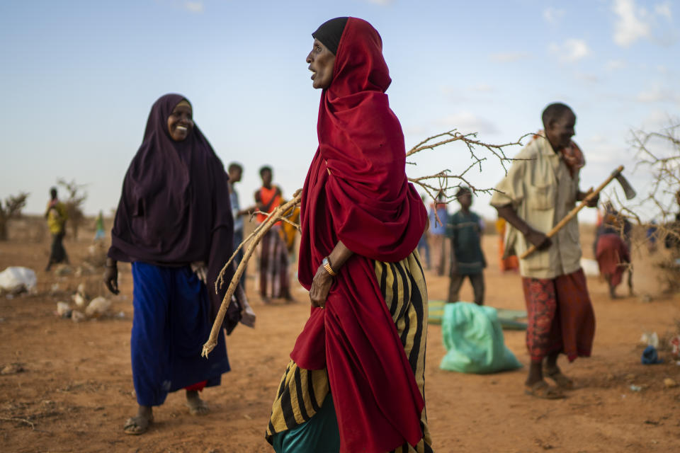 A woman builds shelter at a camp for displaced people on the outskirts of Dollow, Somalia, on Monday, Sept. 19, 2022. Somalia is in the midst of the worst drought anyone there can remember. A rare famine declaration could be made within weeks. Climate change and fallout from the war in Ukraine are in part to blame. (AP Photo/Jerome Delay)