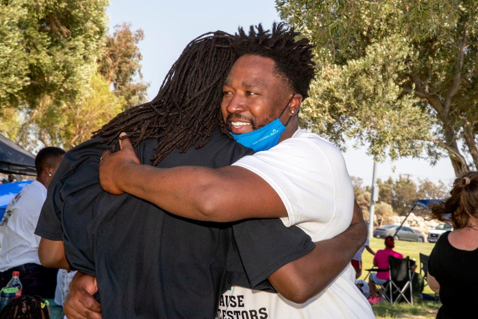 Hasan Brown hugs a friend during the Juneteenth celebration at James O. Jessie Desert Highland Unity Center in Palm Spring, Calif., on June 19, 2021. 