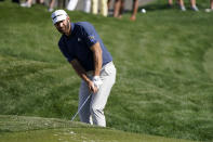 Dustin Johnson chips to the green on the ninth hole during the first round of the The Players Championship golf tournament Thursday, March 11, 2021, in Ponte Vedra Beach, Fla. (AP Photo/John Raoux)