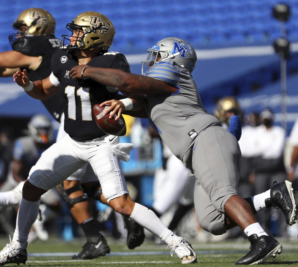 Memphis defensive lineman O'Bryan Goodson (1) drags down Central Florida quarterback Dillon Gabriel (11) during an NCAA college football game Saturday, Oct. 17, 2020, in Memphis, Tenn. (Patrick Lantrip/Daily Memphian via AP)