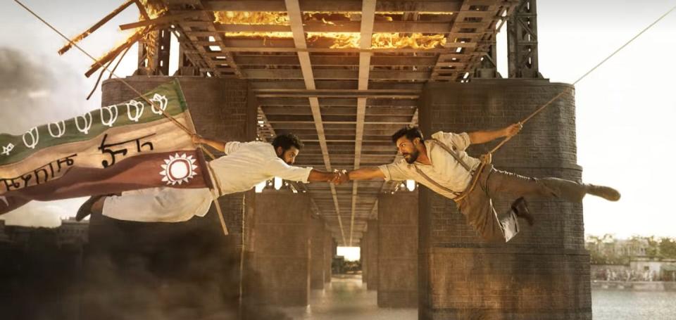Ram Charan and N.T. Rama Rao Jr. lock arms below a bridge