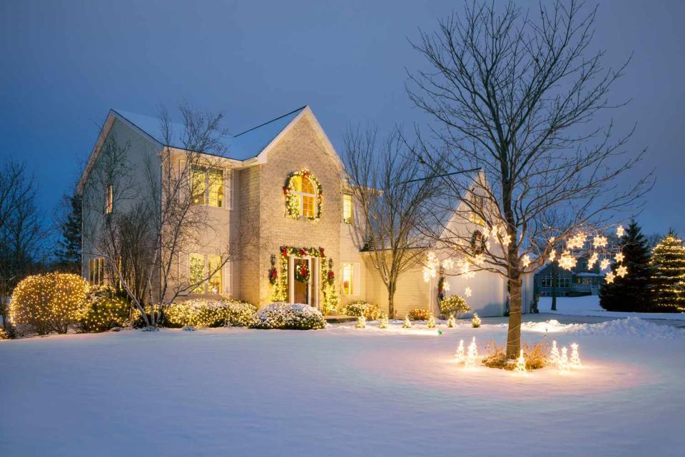 <p>Getty</p> A house decorated for Christmas with snow on the ground.