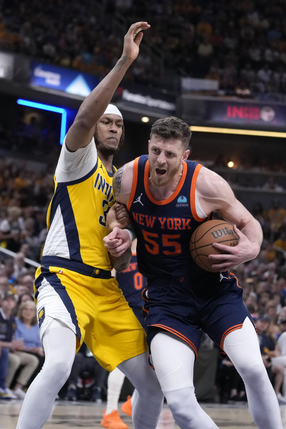 New York Knicks center Isaiah Hartenstein (55) drives past Indiana Pacers center Myles Turner, left, during the first half of Game 4 in an NBA basketball second-round playoff series, Sunday, May 12, 2024, in Indianapolis. (AP Photo/Michael Conroy)