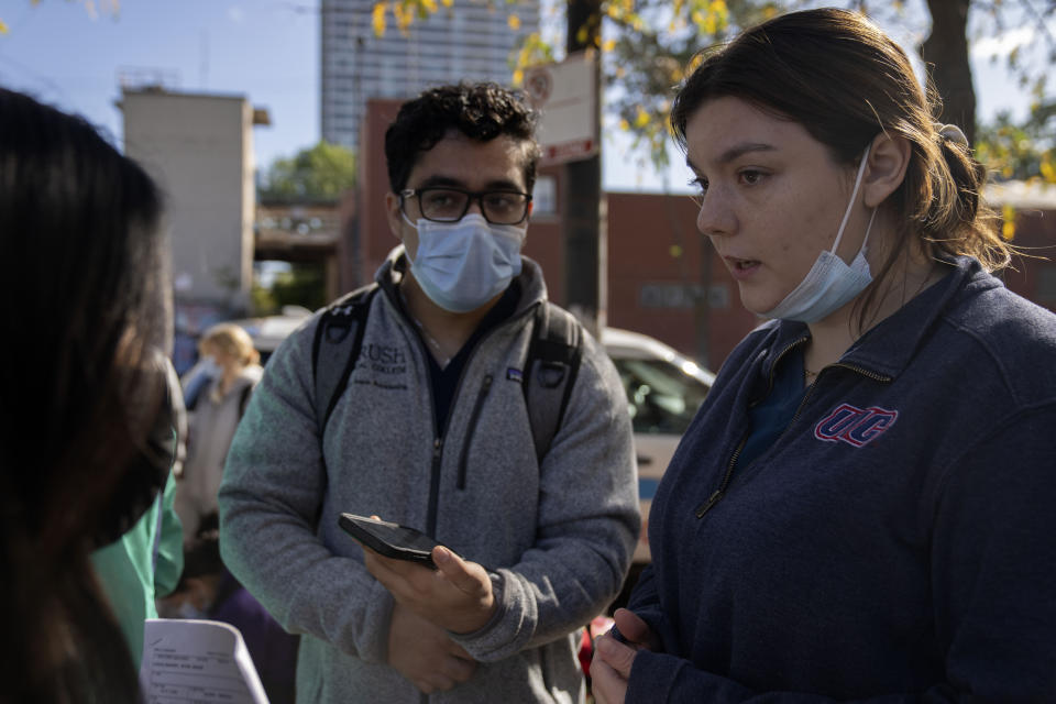 UIC med student Sara izquierdo, right, speaks to other members of the Mobile Migrant Health Team outside of the 1st District police station where migrants are camped, Saturday, Oct. 7, 2023, in Chicago. (AP Photo/Erin Hooley)