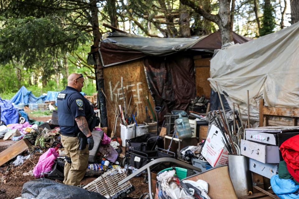 Officer Kevin Ramirez with Salem Police's Homeless Services Team checks on people experiencing homelessness on Thursday, May 11, 2023 in Salem, Ore. Having a consistent team allows the officers to build trust with people experiencing homelessness, Ramirez said.