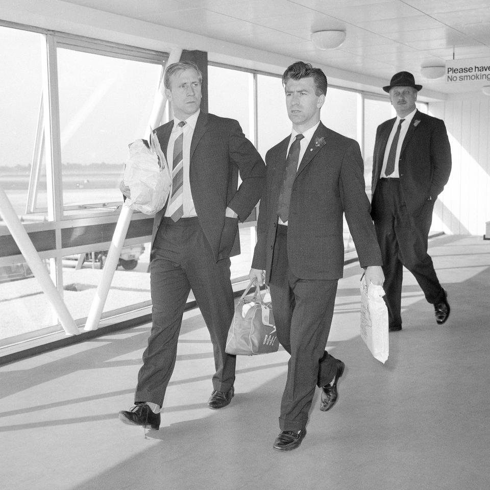 FILE - England footballers Bobby Charlton, left, and Bryan Douglas walk through a terminal building at London Airport, England on June 14, 1962, after flying home from the Football World Cup Chile. England were knocked out in the quarterfinals by Brazil. Bobby Charlton, an English soccer icon who survived a plane crash that decimated a Manchester United team destined for greatness to become the heartbeat of his country's 1966 World Cup-winning team, has died. He was 86. A statement from Charlton's family, released by United, said he died Saturday Oct. 21, 2023 surrounded by his family. (AP Photo/Victor Boynton, file)