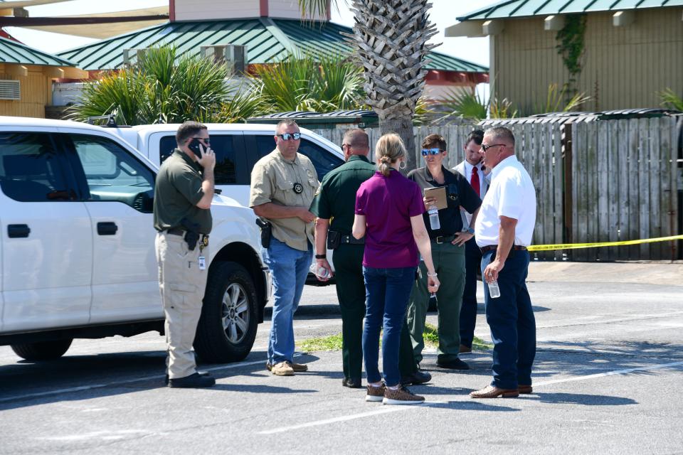 Pictures from a crime scene at The Boardwalk on Okaloosa Island Friday where a machete wielding man injured one person before he was shot by a sheriff's deputy.