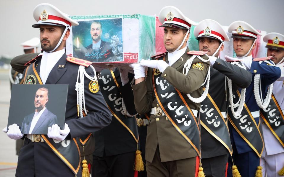 Soldiers carry the body of Raisi at Mehrabad Airport in Tehran