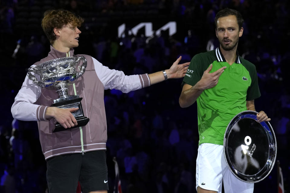 Jannik Sinner, left, of Italy gestures as he holds the Norman Brookes Challenge Cup after defeating Daniil Medvedev, right, of Russia in the men's singles final at the Australian Open tennis championships at Melbourne Park, in Melbourne, Australia, Sunday, Jan. 28, 2024.(AP Photo/Andy Wong)