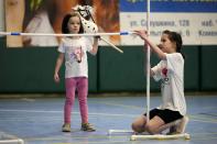 A girl installs an equestrian hurdle during a Hobby horsing competition in St. Petersburg, Russia, on Sunday, April 21, 2024. Several dozen kids, 48 girls and one boy, from first-graders to teenagers gathered in a gymnasium in northern St. Petersburg, Russia's second largest city, for a hobby horsing competition. (AP Photo/Dmitri Lovetsky)