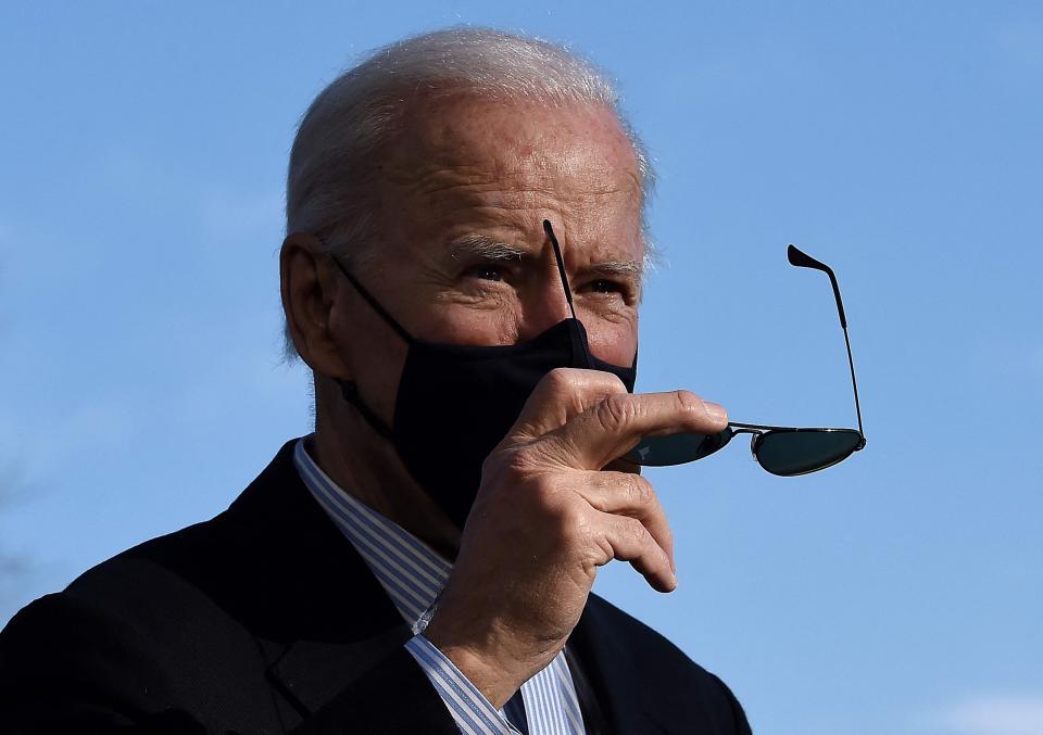 President Joe Biden takes off his sunglasses as he walks across the White House South Lawn upon his return from Camp David.