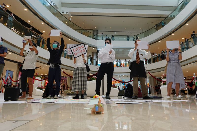 Pro-democracy demonstrators take part in a lunchtime protest against the national security law, at a shopping mall in Hong Kong