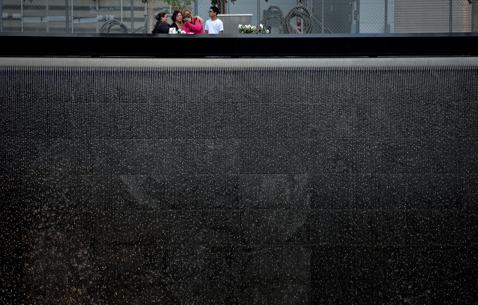 NEW YORK, NY - SEPTEMBER 11: A family stands at the edge of the North Pool during memorial observances held at the site of the World Trade Center on September 11, 2014 in New York City. This year marks the 13th anniversary of the September 11th terrorist attacks that killed nearly 3,000 people at the World Trade Center, Pentagon and on Flight 93.  (Photo by Justin Lane- Pool/Getty Images)