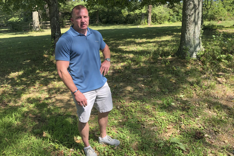 In this photo made on July 29, 2020, Bryan Hillberg, stands in his yard in Waynesville, Ohio. Hillberg was a Marine that was in the Columbus, Ohio-based Lima Company that served in Iraq, when the vehicle immediately behind his in a convoy was blown up by a roadside bomb Aug. 3, 2005, killing 15. Some survivors and families of those killed had planned a 15-year reunion this weekend, but it had to be canceled amid restrictions for the COVID-19 pandemic. (AP Photo/Dan Sewell)