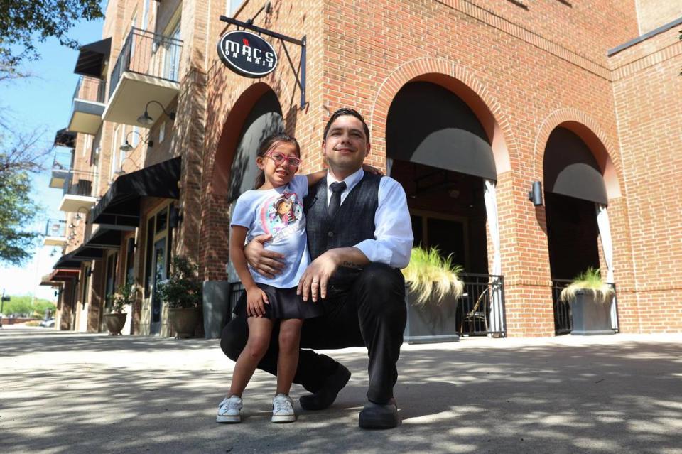 Juan Cordova and his daughter, Camila, 6, in front of Mac’s on Main, his place of employment, on Friday, April 5 in Grapevine. The full price of child care became too expensive for his family without financial aid, Cordova said, and now he and his wife — who is also a server — work opposite shifts and rely on relatives to make their child care situation work.