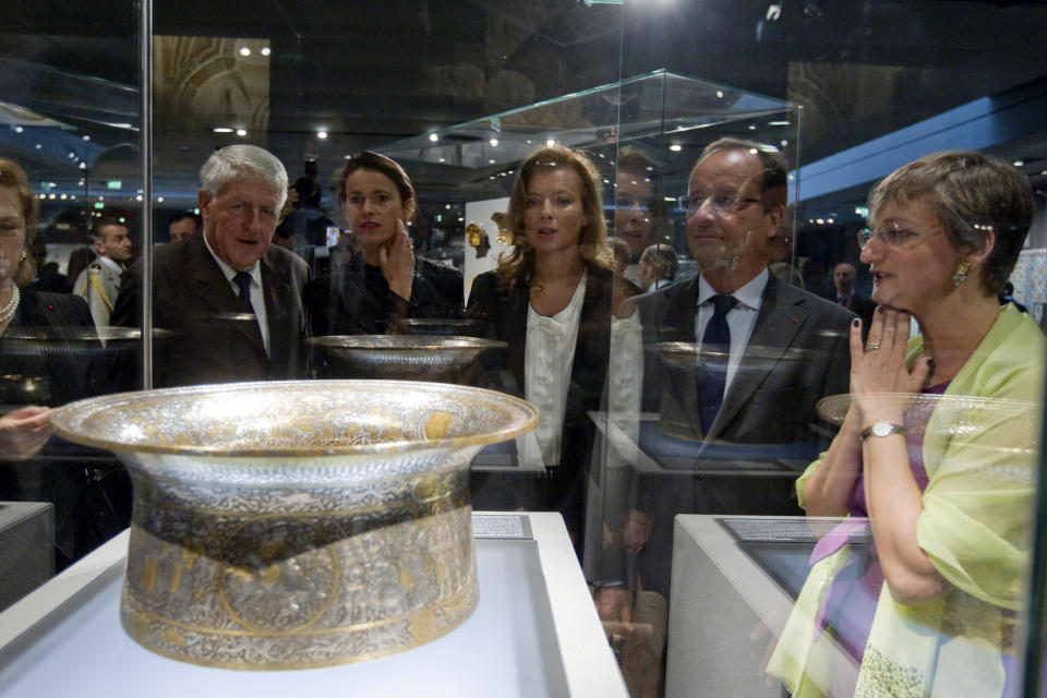 French President Francois Hollande, second right, his companion Valerie Trierweiler, center, Culture minister Aurelie Filippetti, second left, and Sophie Makariou, right, chief of Department of Islamic Arts, look at the Saint Louis baptistery, work of Master Muhammad Ibn al-Zain as they visit the new Department of Islamic Arts galleries at the Louvre museum in Paris, Tuesday Sept. 18, 2012. (AP Photo/Gonzalo Fuentes, Pool)