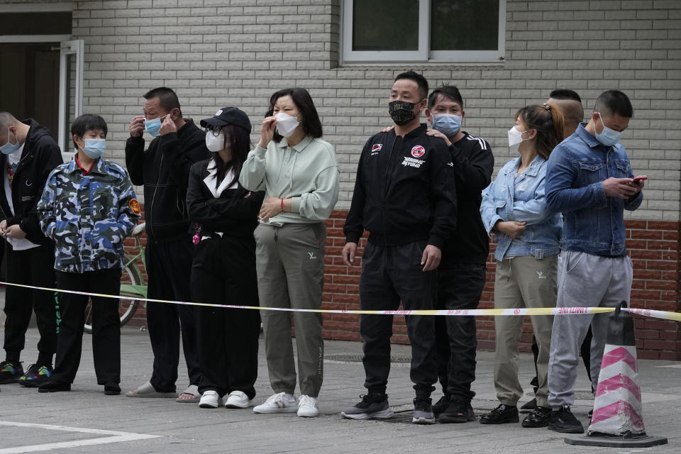 Residents line up for COVID test, Wednesday, April 27, 2022, in Beijing. Workers put up fencing and police restricted who could leave a locked-down area in Beijing on Tuesday as authorities in the Chinese capital stepped up efforts to prevent a major COVID-19 outbreak like the one that has all but shut down the city of Shanghai. (AP Photo/Ng Han Guan)