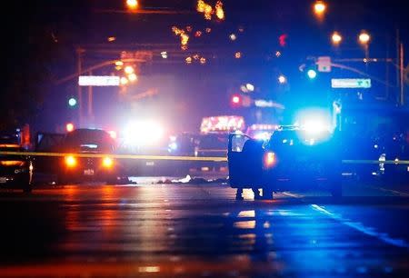 Police vehicles line the street around a vehicle in which two suspects were shot following a mass shooting in San Bernardino, California December 2, 2015. REUTERS/Mike Blake