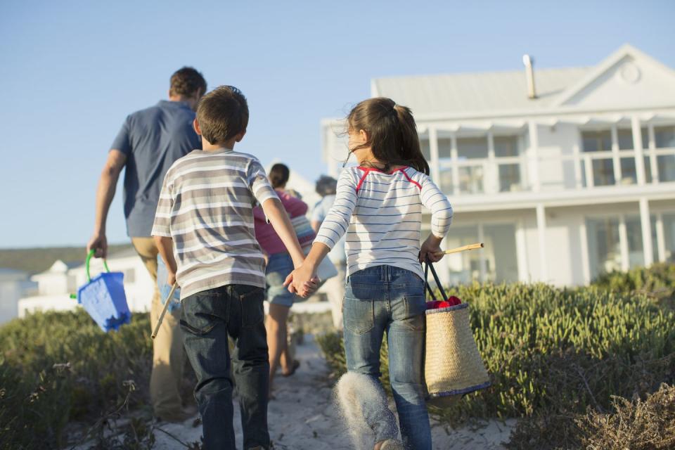 brother and sister holding hands on a beach path