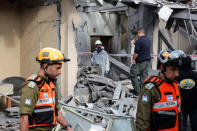 Israeli policemen and soldiers inspect a damaged house that was hit by a rocket north of Tel Aviv Israel March 25, 2019. REUTERS/ Ammar Awad