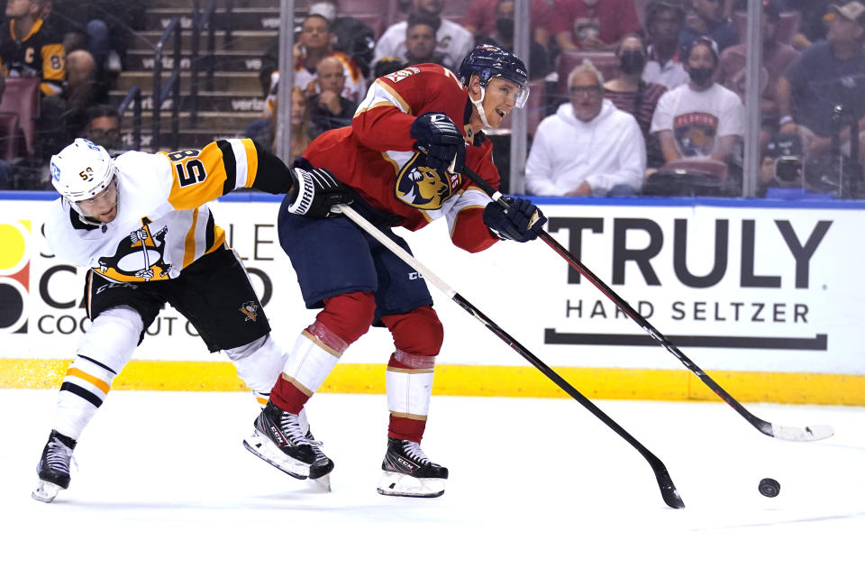 Florida Panthers defenseman Gustav Forsling, right, shoots as Pittsburgh Penguins defenseman Kris Letang (58) defends during the second period of an NHL hockey game Thursday, Oct. 14, 2021, in Sunrise, Fla. (AP Photo/Lynne Sladky)