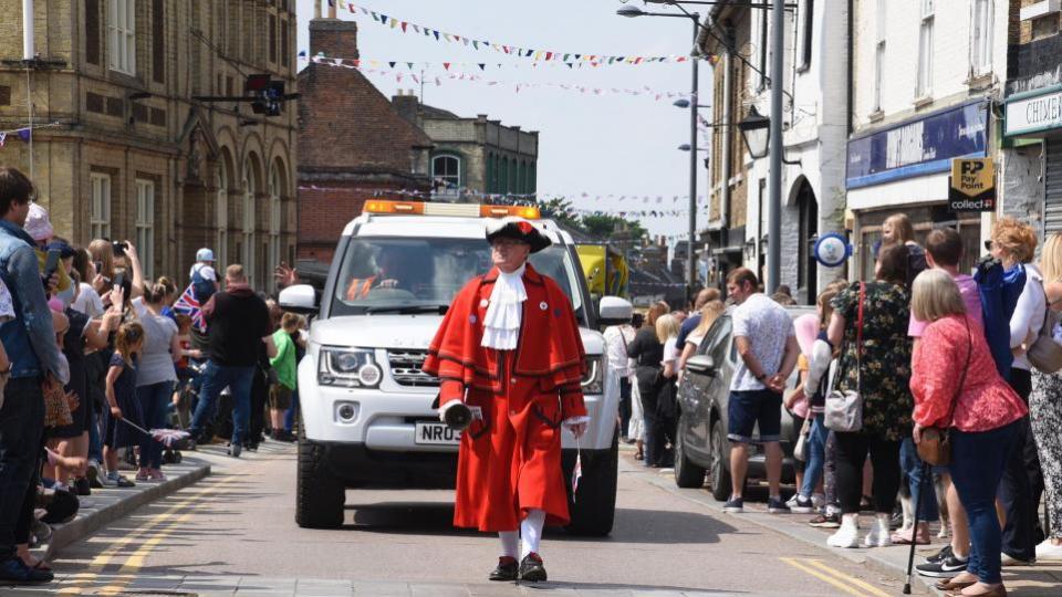 Eastern Daily Press: The Downham Market town crier leads the parade through the town in 2022