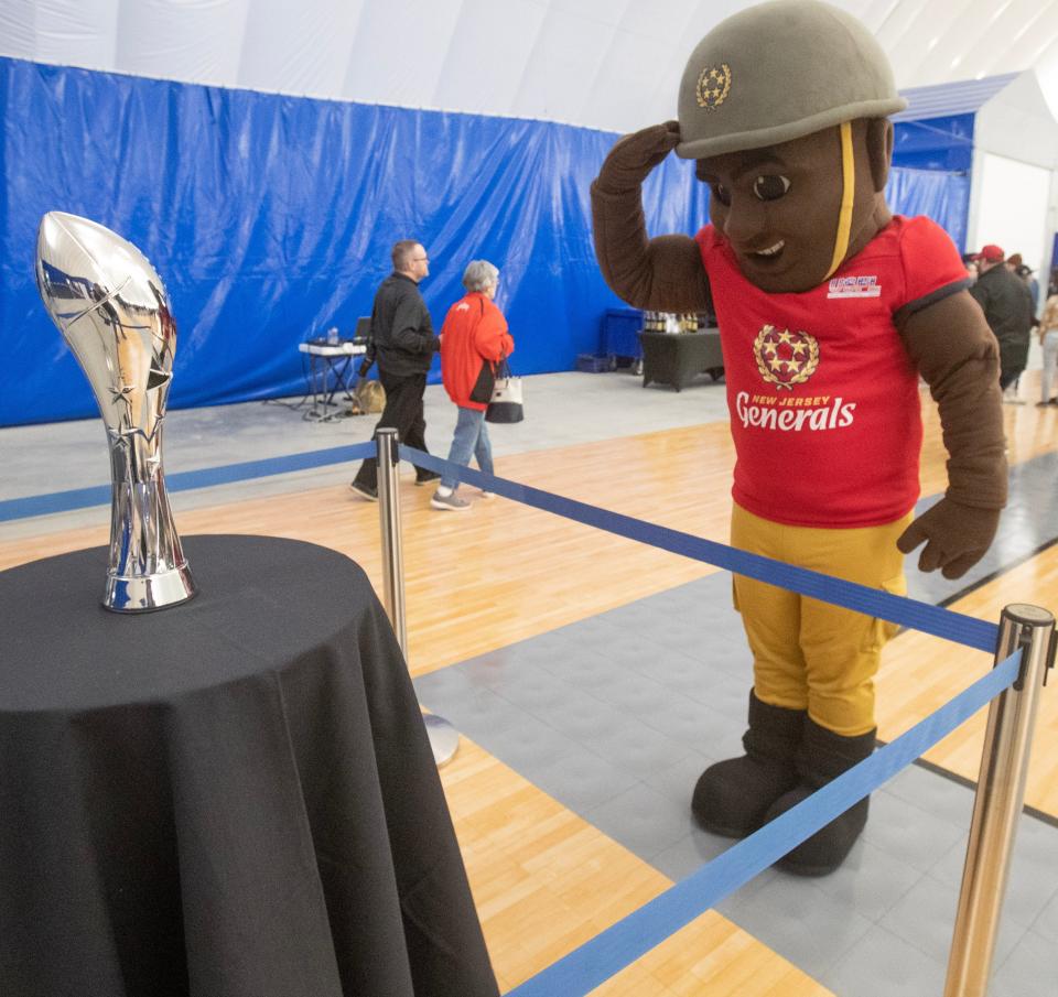 The New Jersey Generals mascot "General Jersey" salutes the USFL championship trophy at a USFL season ticket holder event held at the Hall of Fame Village Center for Performance.