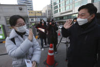 A student waves to her father before entering a high school to take the college entrance exam in Seoul, South Korea, Thursday, Dec. 3, 2020. South Korean officials urged on Wednesday people to remain at home if possible and cancel gatherings as about half a million students prepare for the crucial national college exam. (AP Photo/Ahn Young-joon)