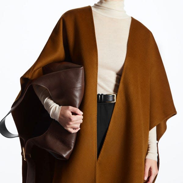 A model wears a brown cape from COS.