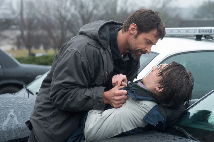 Hugh Jackman holding Paul Dano by the jacket against a car in Prisoners (2013).