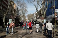 Women wearing protective masks, due to the coronavirus outbreak, walk by Las Ramblas in Barcelona