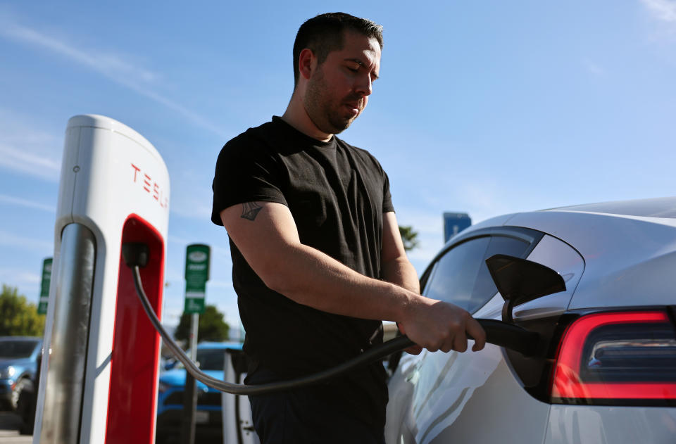 Robert Chávez conecta sus autos eléctricos Tesla para recargarlos en una estación Tesla Supercharger el 16 de enero de 2024 en Burbank, California. (Foto de Mario Tama/Getty Images)
