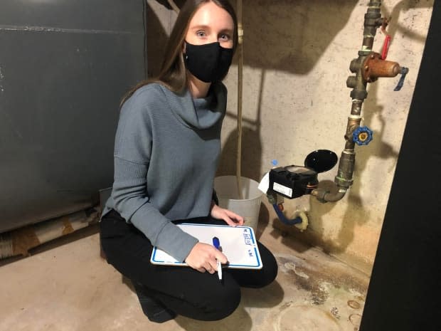 Emily VanIderstine, watershed co-ordinator, starts the audit by teaching homeowners how to read their water meter, and how to check it for leaks.   (Nancy Russell/CBC - image credit)