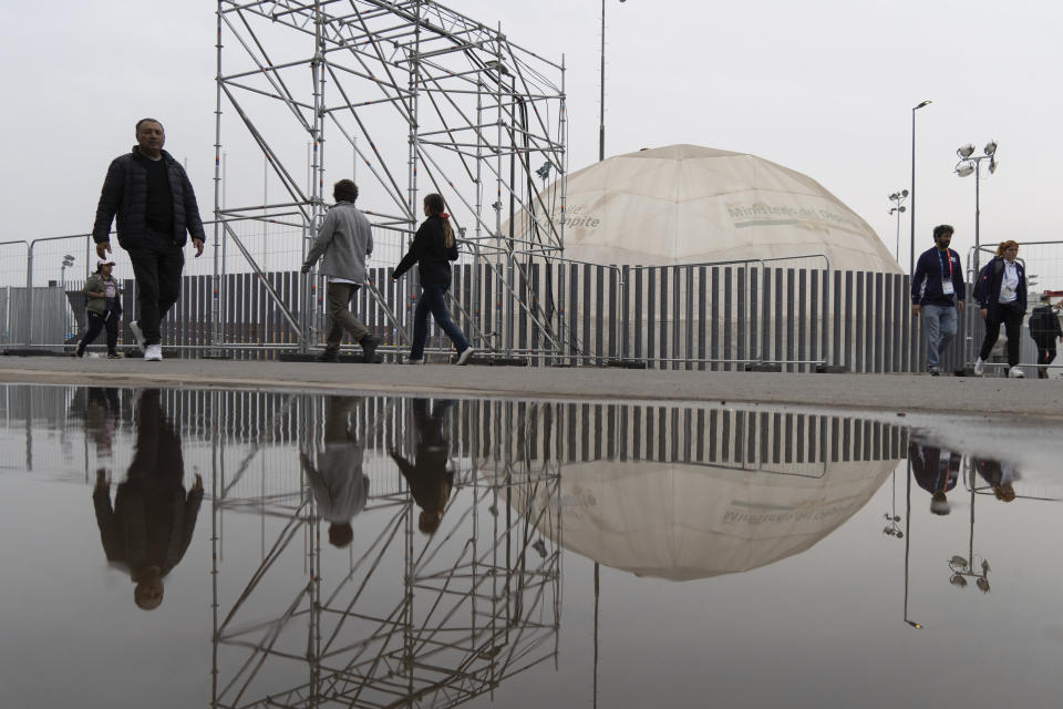 El reflejo de la gente al caminar en el complejo deportivo del Estadio Nacional durante los Juegos Panamericanos en Santiago, Chile, el sábado 21 de octubre de 2023. (AP Foto/Matías Basualdo)