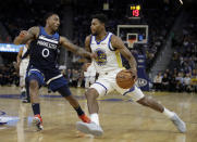 Golden State Warriors' Glenn Robinson III, right, drives the ball as Minnesota Timberwolves' Jeff Teague (0) defends during the first half of an NBA preseason basketball game Thursday, Oct. 10, 2019, in San Francisco. (AP Photo/Ben Margot)