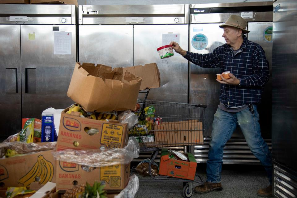 Food pantry assistant driver Mark Simpson sorts through a variety of food while picking an order for someone at the Lancaster Fairfield Community Action Food Bank on Feb. 8, 2023 in Lancaster, Ohio.