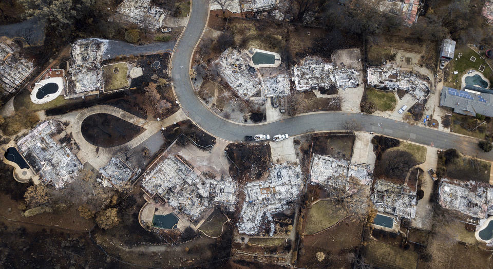 FILE - Homes leveled by the Camp Fire line Valley Ridge Drive in Paradise, Calif., on Dec. 3, 2018. The Camp Fire bears many similarities to the deadly wildfire in Hawaii. Both fires moved so quickly residents had little time to escape. (AP Photo/Noah Berger, File)