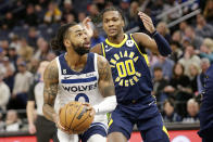 Minnesota Timberwolves guard D'Angelo Russell (0) shoots on Indiana Pacers guard Bennedict Mathurin (00) in the second quarter of an NBA basketball game, Wednesday, Dec. 7, 2022, in Minneapolis. (AP Photo/Andy Clayton-King)