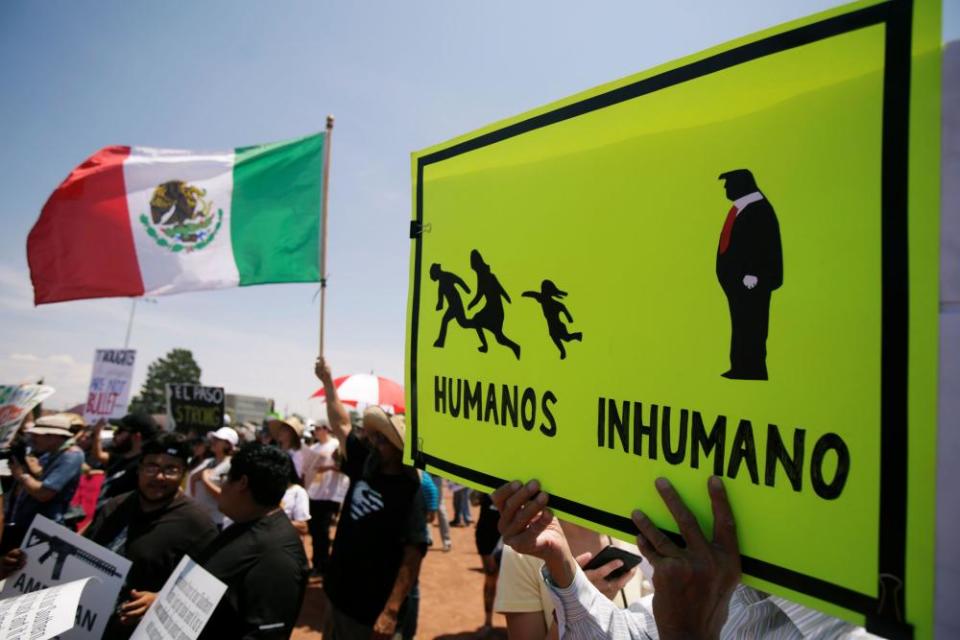 People hold banners while taking part in a rally in El Paso.