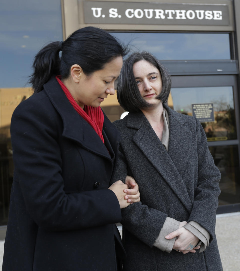 Cleopatra De Leon, left, and partner, Nicole Dimetman, right, arrive at the U.S. Federal Courthouse, Wednesday, Feb. 12, 2014, in San Antonio, where a federal judge is expected to hear arguments in a lawsuit challenging Texas' ban on same-sex marriage. (AP Photo/Eric Gay)