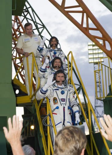 Image provided by NASA shows Expedition 32 Soyuz Commander Yuri Malenchenko (bottom), JAXA Flight Engineer Akihiko Hoshide and NASA Flight Engineer Sunita Williams (top) wave farewell from the base of the Soyuz rocket at the Baikonur Cosmodrome in Kazakhstan on July 15