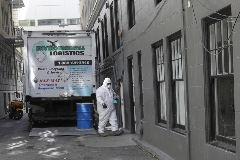 A worker in a haz-mat suit walks to an entrance to the Abigail Hotel in San Francisco, Thursday, April 2, 2020. Since the beginning of an international pandemic, officials in California have said one population is particularly vulnerable to contracting the coronavirus and spreading it to others: the homeless. The Abigail Hotel is one of several private hotels San Francisco has contracted with to take vulnerable people who show symptoms or are awaiting test results for coronavirus. (AP Photo/Jeff Chiu)