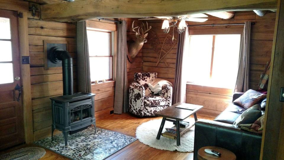 The interior of the two-bedroom "Simple Blessings Cabin" includes rustic touches like a big, comfy "cow" chair, log beds and chandeliers.