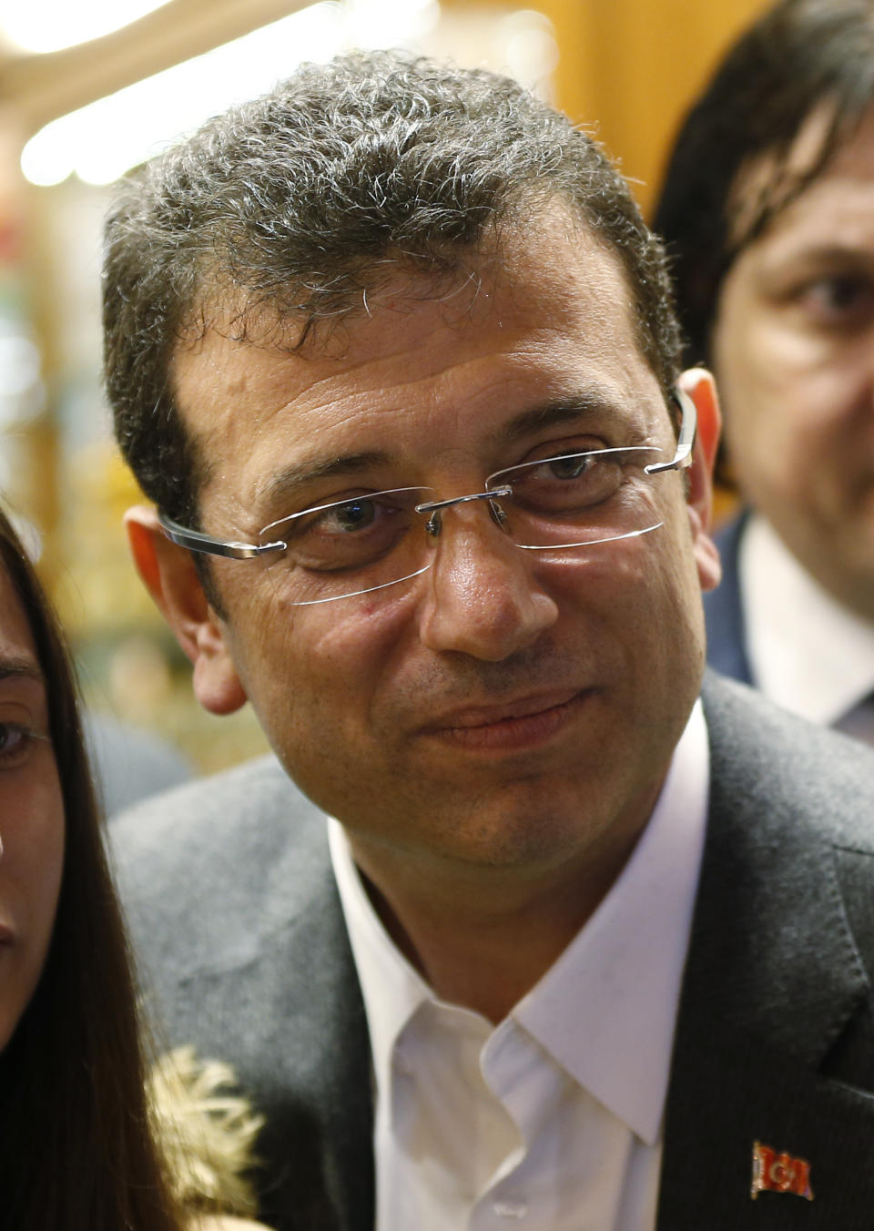 FILE-In this Tuesday, March 12, 2019 file photo, Ekrem Imamoglu, the mayoral candidate for Istanbul of Republican People's Party (CHP), poses for pictures with people during a campaign visit at the Spice Market, or the Egyptian Bazaar, in Istanbul, ahead of local elections scheduled for March 31, 2019. The race for the mayor of Istanbul could be a tight one and Turkey's President Recep Tayyip Erdogan has chosen former Prime Minister Binali Yildirim as a high-profile candidate. For Erdogan, the local elections are not just a vote to decide who should collect the garbage and maintain roads, they are about Turkey's future national "survival." (AP Photo/Lefteris Pitarakis, File)