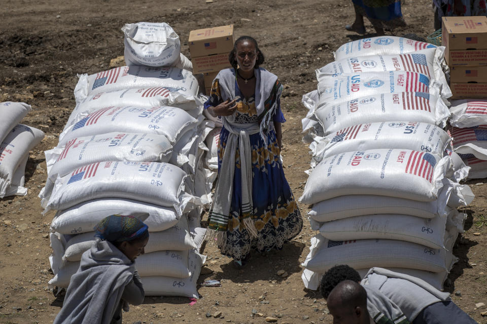 FILE - An Ethiopian woman stands by sacks of wheat to be distributed by the Relief Society of Tigray in the town of Agula, in the Tigray region of northern Ethiopia on May 8, 2021. In 2023 urgently needed grain and oil have disappeared again for millions caught in a standoff between Ethiopia's government, the United States and United Nations over what U.S. officials say may be the biggest theft of food aid on record. (AP Photo/Ben Curtis, File)